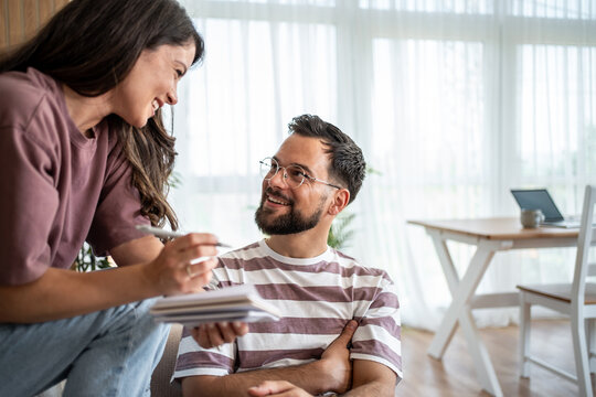 Young couple planning finances at home, discussing bills and expenses