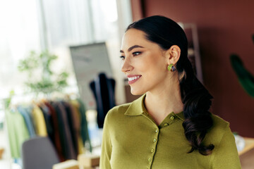 Young professional woman in stylish green outfit smiling confidently in a modern workspace with...