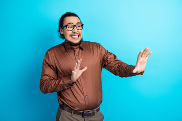 Young man in formal attire expressing an energetic gesture on a turquoise background symbolizing...