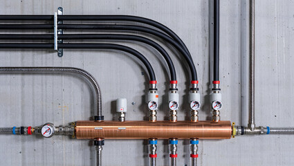 This setup features a collection of pipes and valves arranged systematically on a concrete wall, illustrating an advanced plumbing system used in industrial applications