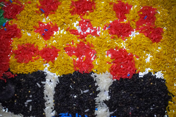 Decorative colorful Rice the floor, likely part of rangoli or religious decoration for a festival.