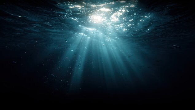 Sunlight beams through deep dark water