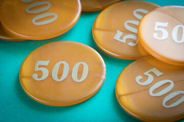 Fiches arancioni per gioco d'azzardo su superficie verde © errem