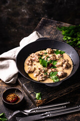 Meatballs in sour cream sauce in a frying pan