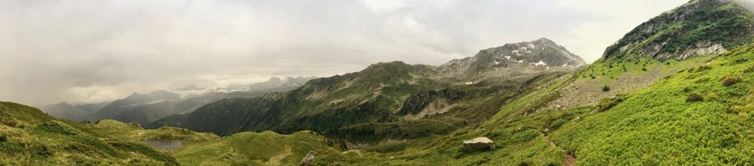 Panoramic view of lush green mountains under a cloudy sky