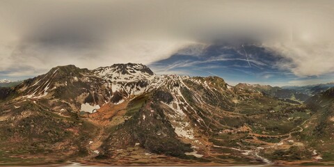 Panoramic mountain landscape with snow-covered peaks under expansive sky atmosphere