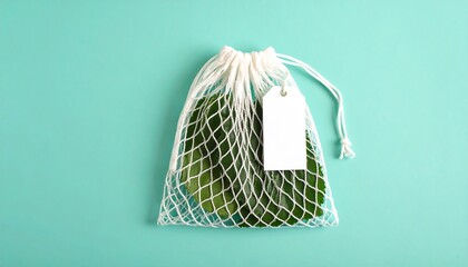 Mesh Bag With Green Leaves And Blank Tag Mockup On Turquoise Background