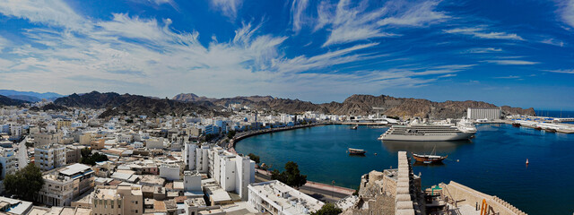 Stunning panoramic cityscape of Muttrah bay and mountains in Muscat, Oman. Wide travel shot.
