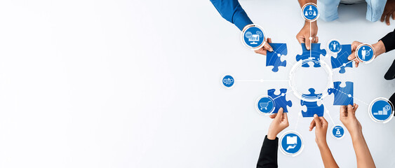 This image showcases multiple hands connecting blue puzzle pieces, symbolizing teamwork and collaboration in a modern business environment for strategic planning. Amity