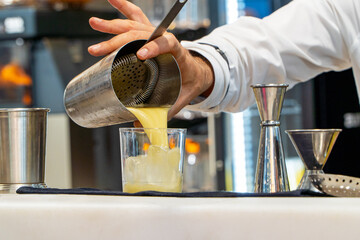 Bartender serving refreshing pina colada cocktail on a glass with ice