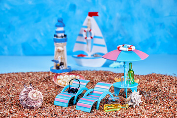 postcard with an image of a summer relaxation corner on the sea beach with sun loungers and a stand with an umbrella on a blue background with a sailboat and a lighthouse