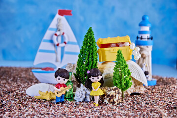 cute romantic doll composition with a girl and a boy playing her guitar on the background of a seascape, concept of the charm of youth and the beginning of a relationship