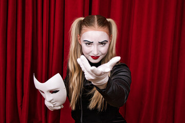 On stage, the focus is on a mime artist with a mask in his hand. Close-up portrait