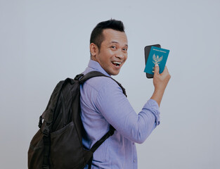 Portrait of happy asian traveler tourist man holding passport tickets and backpack isolated on...