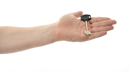 Key held in hand against a white background highlighting the detail of the key design and hand...