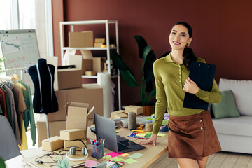 Starting a small business entrepreneur in a fashion atelier working on a project, surrounded by...