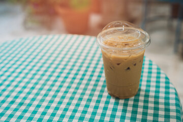 Coffee in cafe. Refreshing Iced Coffee in Transparent Cup on Checkered Tablecloth in Outdoor Café Setting