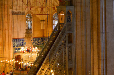 A large building with a dome and arches. The inside is lit up with candles