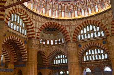 A large building with a dome and arches. The inside is lit up with candles