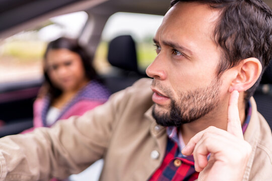 Couple having car trouble listening to strange noise