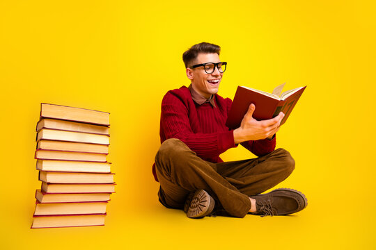 Intelligent student Handsome Young Male Student Reading a Book Against a Bright Yellow Background