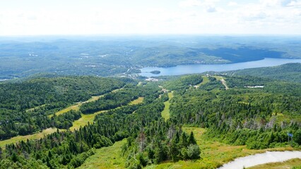 Majestic Green Mountain Peak Towering Over a Serene Lake and Charming Village in the Distance
