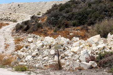 Limestone Quarry Debris Near Dry Hill Trail, Pile of white limestone rubble beside a dirt path in a...