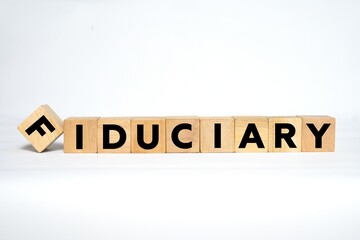 The word "FIDUCIARY" spelled out using wooden blocks with bold black letters on a clean white background.