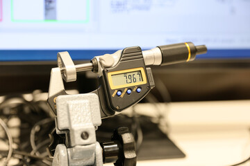 An electronic micrometer and several control and measuring instruments are on display at a trade fair for industrial tools and machinery.