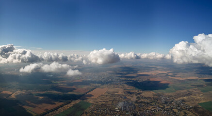 Aerial view at high altitude of earth covered with puffy cumulus clouds forming before rainstorm