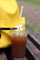 Coffee with juice in a disposable plastic cup with a straw. Coffee with orange juice, syrup and...