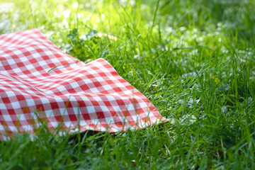 Yellow checkered cloth,checked towel top view on green grass.Food advertisement blank.Picnic towel empty space.Tablecloth  outdoor.