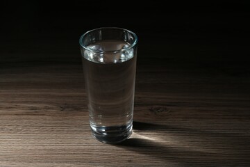 Fresh water in glass on wooden table