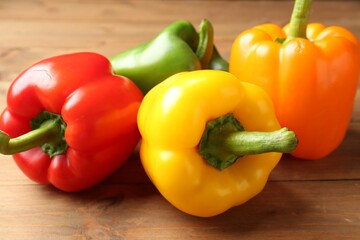 Ripe colorful bell peppers on wooden table, closeup