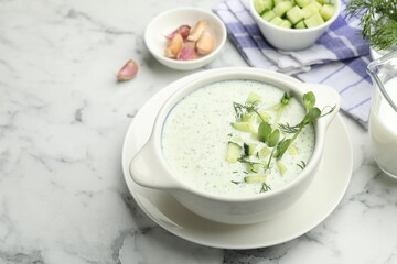 Tasty cucumber soup with dill, microgreens and ingredients on white marble table, closeup