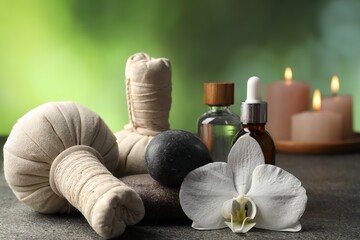 Composition with spa stones and herbal bags on grey table, closeup