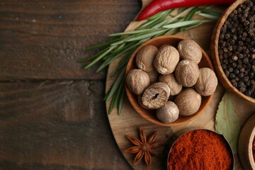 Different aromatic spices on wooden table, flat lay. Space for text