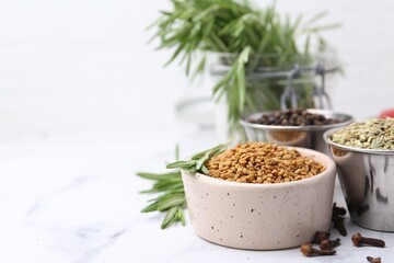 Different aromatic spices on white marble table, closeup. Space for text