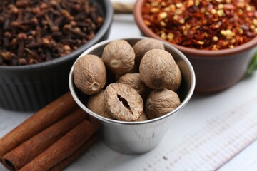 Different aromatic spices on white wooden table, closeup