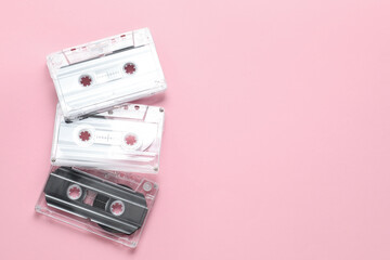 Audio cassettes with magnetic tapes on pink background, flat lay. Space for text