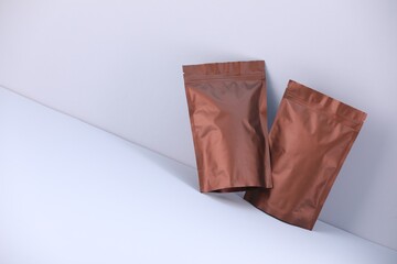 Two zipper stand-up pouches on light grey background. Mockup for design