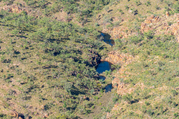 Kimberley landscape directly below flat-tp landforms fractured by crevasse and waterholes