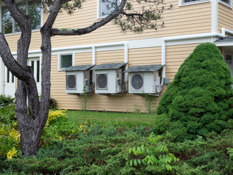 Three heat pumps with small shingle roofs to make them last longer