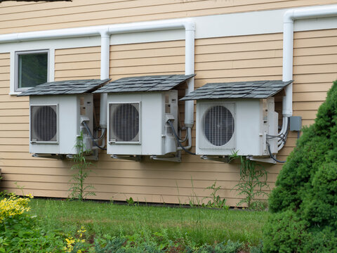 Three heat pumps with small shingle roofs to make them last longer