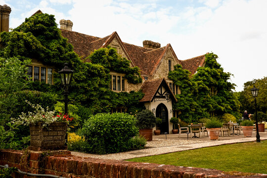 Ashford, Willesborough, England, UK - May 26, 2025. Charming historic facade of Boys Hall in Kent, England, adorned with lush green wisteria at the end of May. The elegant 17th-century country house 