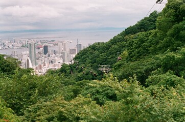 Aerial View of Urban Landscape and Lush Green Forest with Cable Cars
