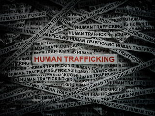 Strips of newspaper with the words Human Trafficking typed on them. Close up.