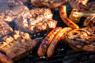 Pork chops, steak, sausages on barbecue grill