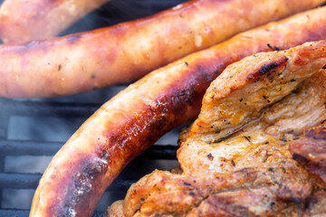 Pork chops, steak, sausages on barbecue grill
