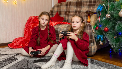 Cute little children playing video game at home on Christmas eve